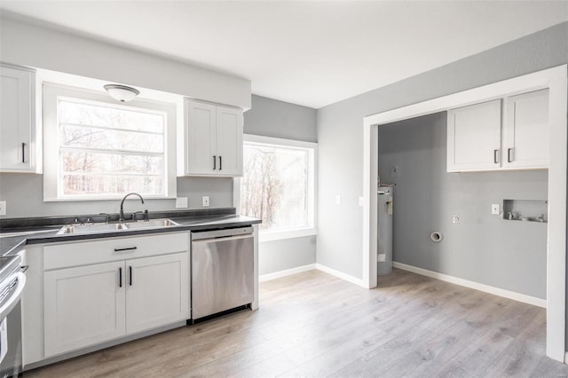 kitchen featuring sink, water heater, light hardwood / wood-style floors, white cabinets, and appliances with stainless steel finishes