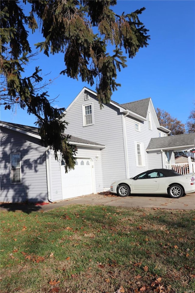 view of side of home featuring a lawn and a garage