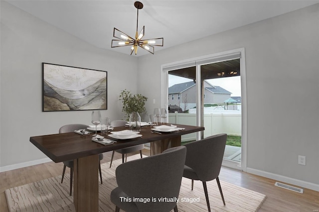 dining space with a chandelier and light hardwood / wood-style flooring