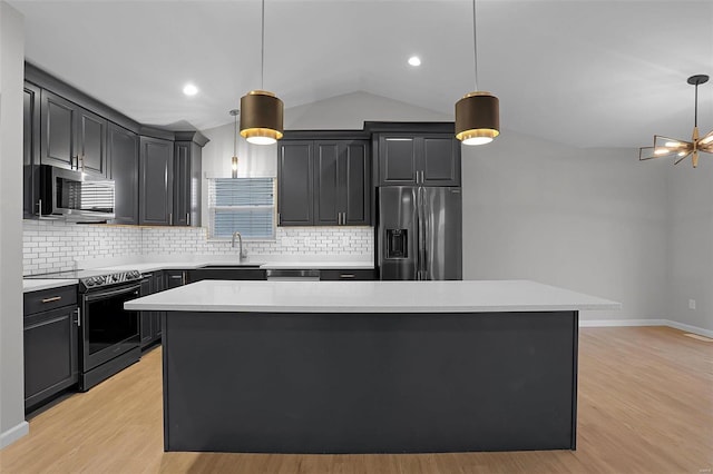 kitchen with light hardwood / wood-style floors, a center island, hanging light fixtures, and appliances with stainless steel finishes