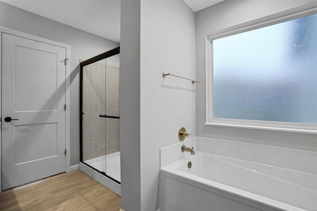 bathroom featuring shower with separate bathtub and wood-type flooring