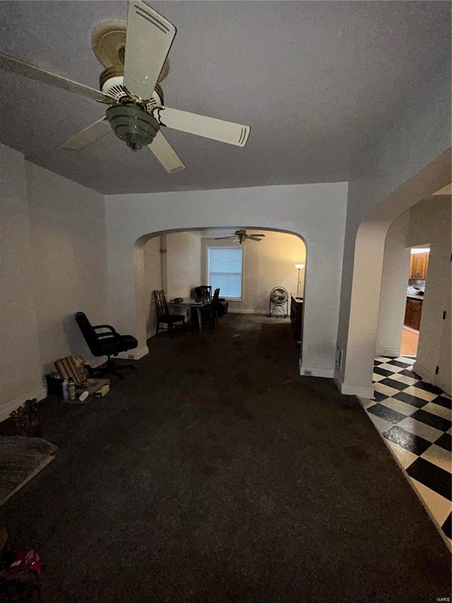 unfurnished living room featuring ceiling fan and a textured ceiling