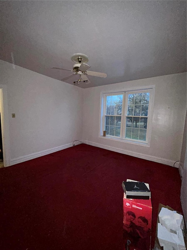 carpeted empty room featuring ceiling fan and a textured ceiling