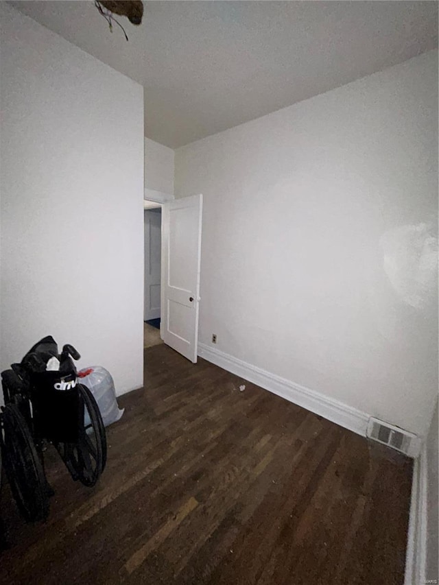 unfurnished room with dark hardwood / wood-style flooring