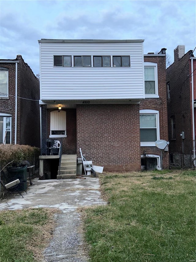 view of front facade with a front lawn and central air condition unit