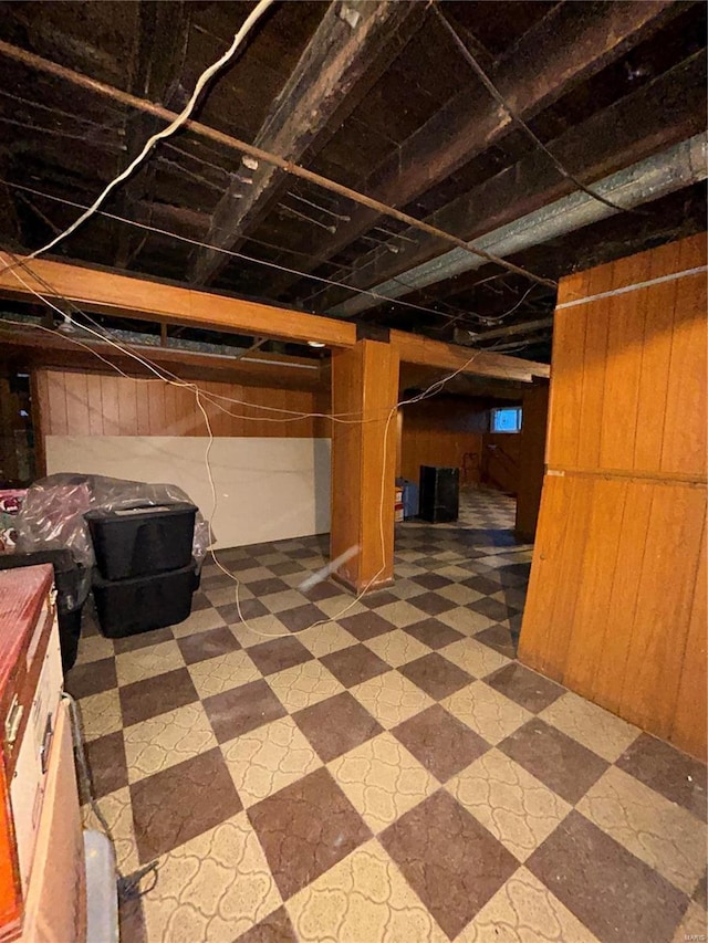 basement featuring wood walls