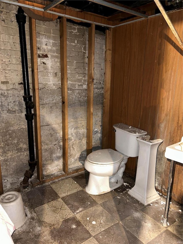 bathroom with wood walls and toilet