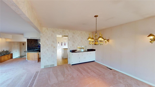 unfurnished dining area with carpet floors and a notable chandelier