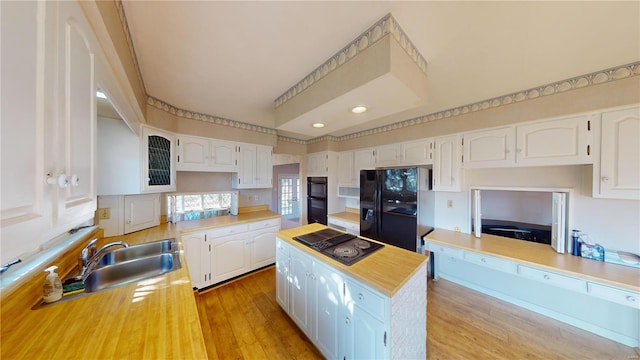 kitchen with light wood-type flooring, white cabinetry, and black appliances