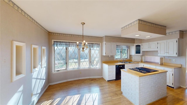 kitchen featuring light wood-type flooring, a center island, white cabinetry, and hanging light fixtures