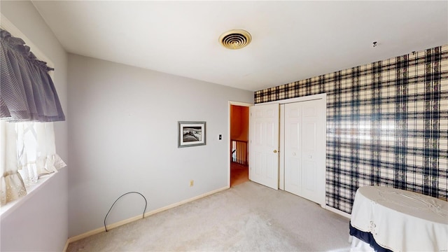 unfurnished bedroom featuring light carpet and a closet