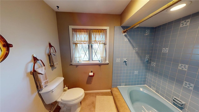 bathroom featuring tiled shower / bath combo and toilet