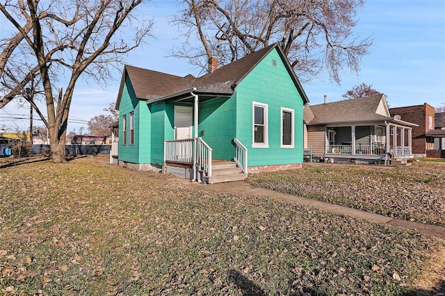 view of front of property with a sunroom and a front lawn