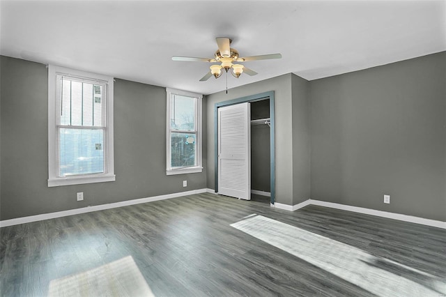 unfurnished bedroom with ceiling fan, dark hardwood / wood-style floors, and a closet