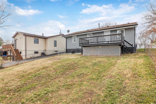 back of property with a deck, a yard, and central air condition unit