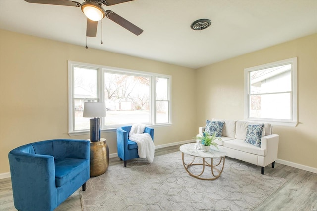 living area with light wood-type flooring and ceiling fan