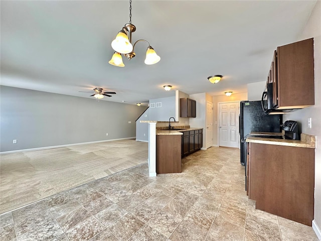 kitchen featuring dark brown cabinets, sink, ceiling fan with notable chandelier, and decorative light fixtures