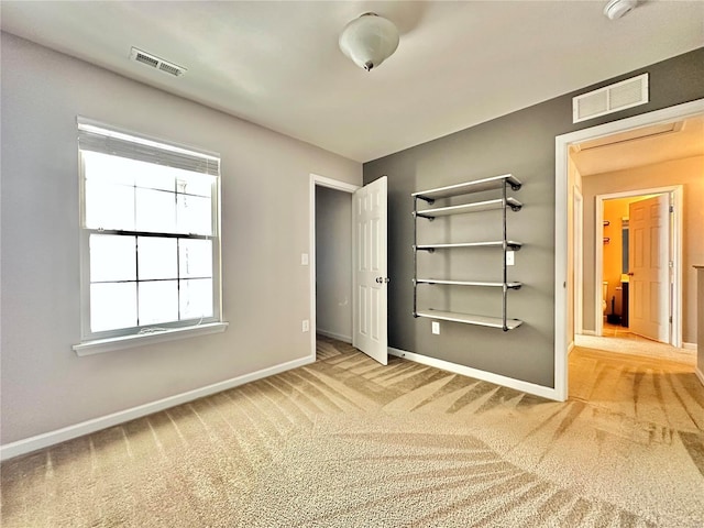 unfurnished bedroom featuring light colored carpet and a closet