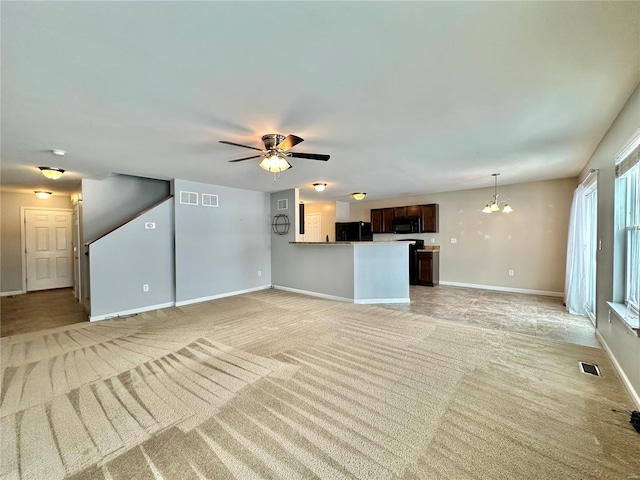 unfurnished living room with light carpet and ceiling fan with notable chandelier