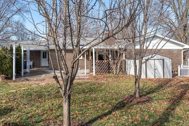 view of front of house with a patio area, a front lawn, and a storage unit