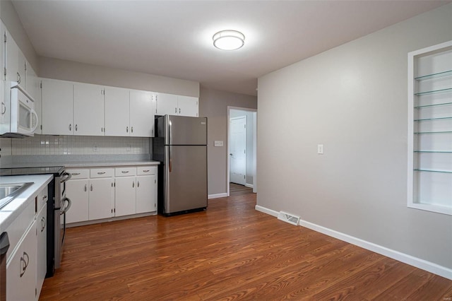 kitchen featuring tasteful backsplash, stainless steel appliances, hardwood / wood-style floors, and white cabinets