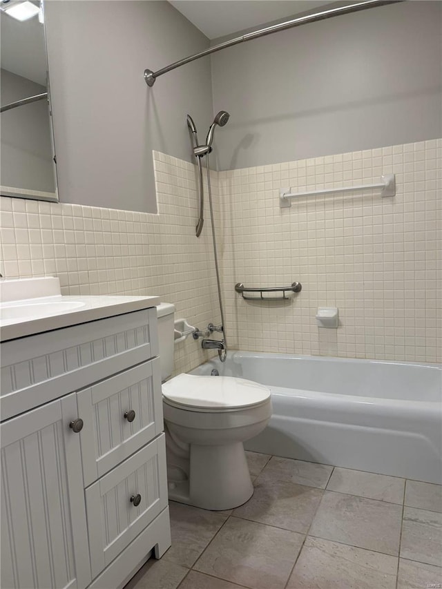 full bathroom featuring tile walls, vanity, tile patterned floors, toilet, and tiled shower / bath