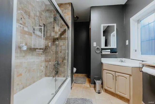 full bathroom featuring tile patterned flooring, vanity, toilet, and bath / shower combo with glass door