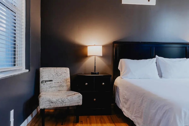 bedroom with hardwood / wood-style floors and multiple windows