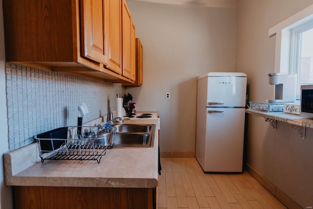 kitchen featuring tasteful backsplash, light hardwood / wood-style flooring, and white fridge