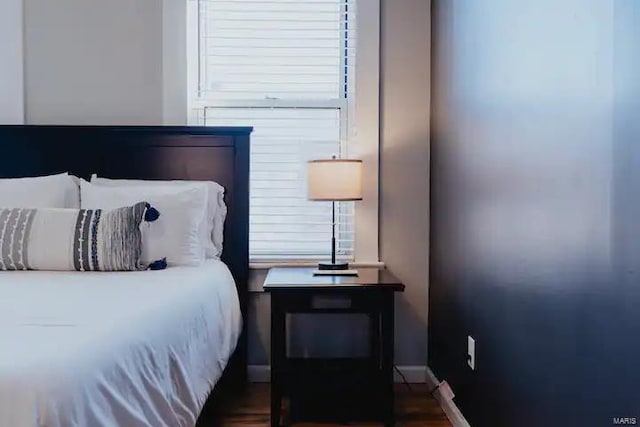 bedroom with dark wood-type flooring