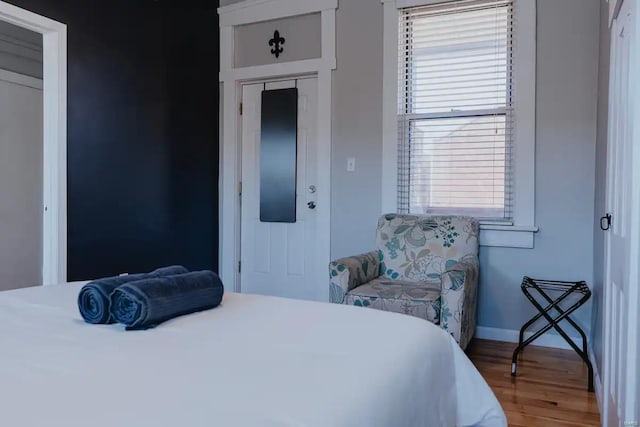 bedroom with a closet, multiple windows, and hardwood / wood-style flooring