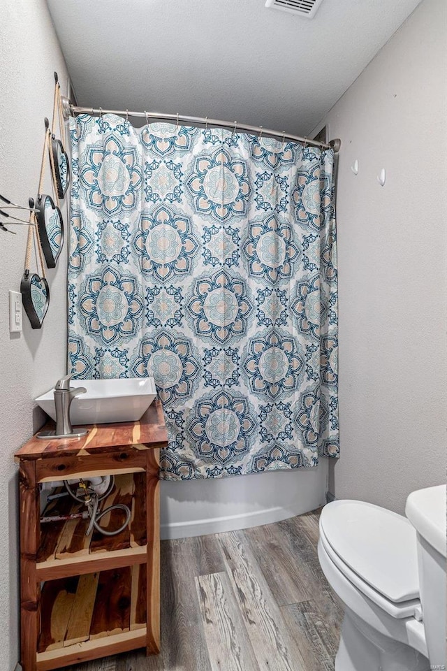 full bathroom featuring sink, toilet, shower / tub combo with curtain, and hardwood / wood-style flooring