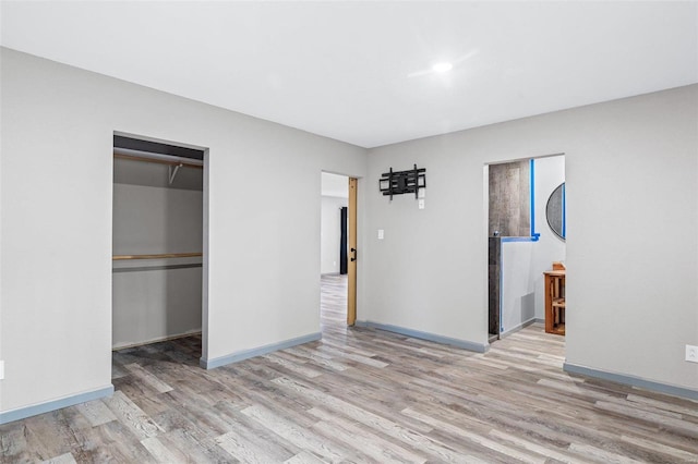 unfurnished bedroom featuring light hardwood / wood-style flooring and a closet