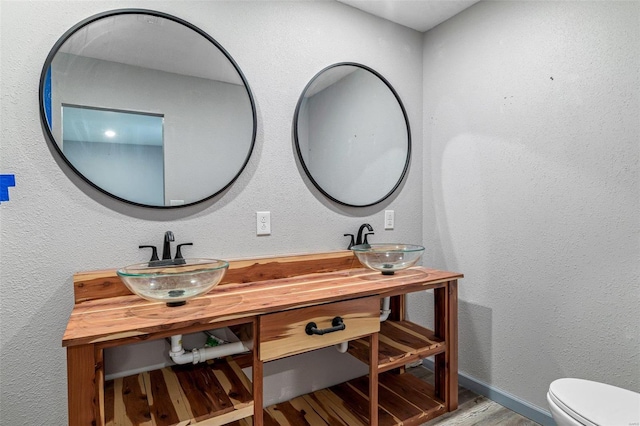 bathroom featuring vanity, toilet, and wood-type flooring