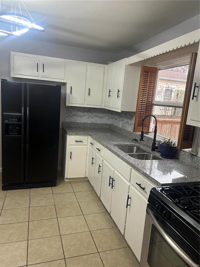 kitchen featuring tasteful backsplash, black fridge with ice dispenser, sink, white cabinetry, and range with gas stovetop