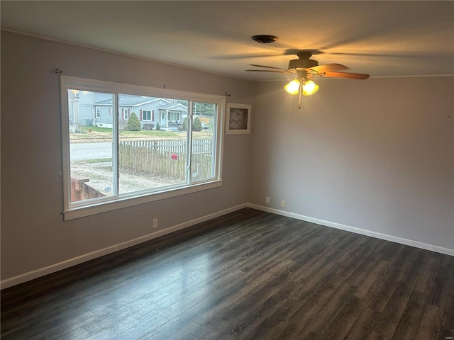 empty room with ceiling fan, dark wood-type flooring, and ornamental molding