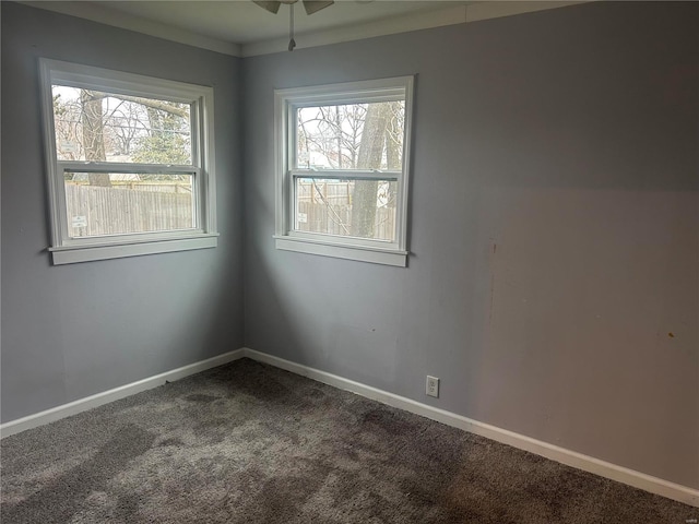 carpeted empty room featuring ornamental molding, ceiling fan, and a healthy amount of sunlight