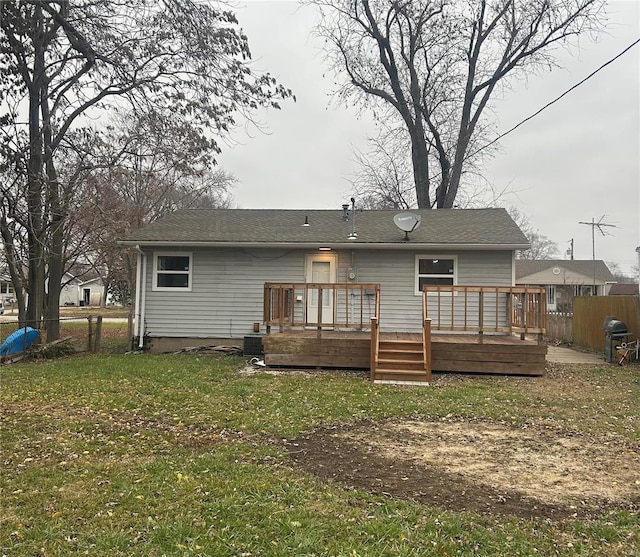 rear view of property with a yard and a wooden deck