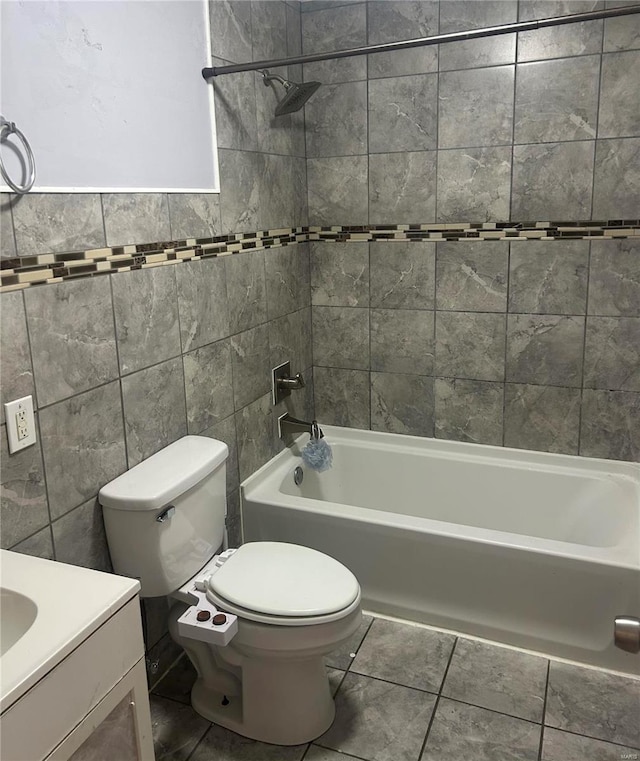 full bathroom featuring tile patterned floors, vanity, tiled shower / bath combo, tile walls, and toilet