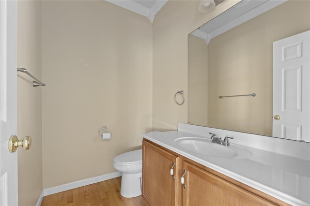 bathroom featuring hardwood / wood-style floors, vanity, toilet, and ornamental molding