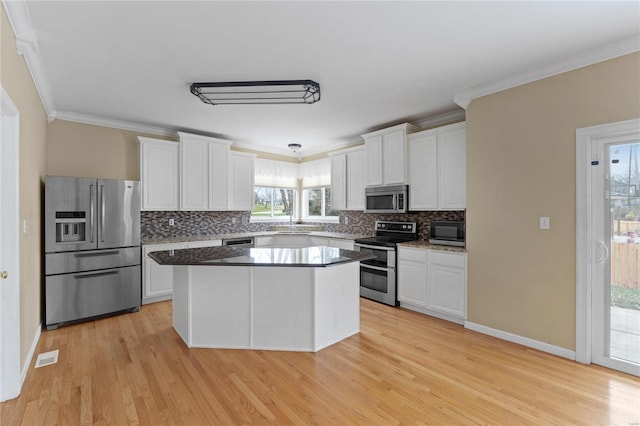 kitchen with white cabinetry, a kitchen island, and appliances with stainless steel finishes