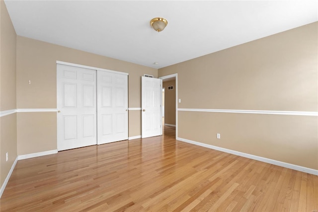 unfurnished bedroom with light wood-type flooring and a closet