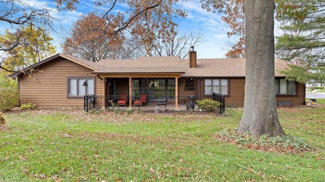 rear view of property featuring a lawn and a patio