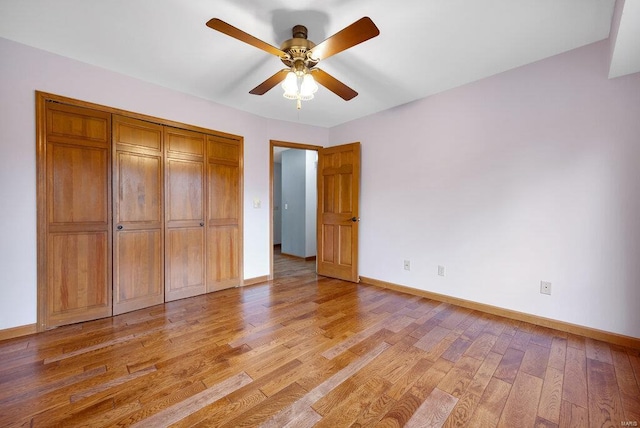 unfurnished bedroom featuring a closet, light hardwood / wood-style floors, and ceiling fan