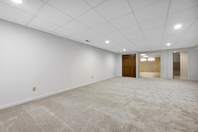 basement with carpet flooring and a paneled ceiling