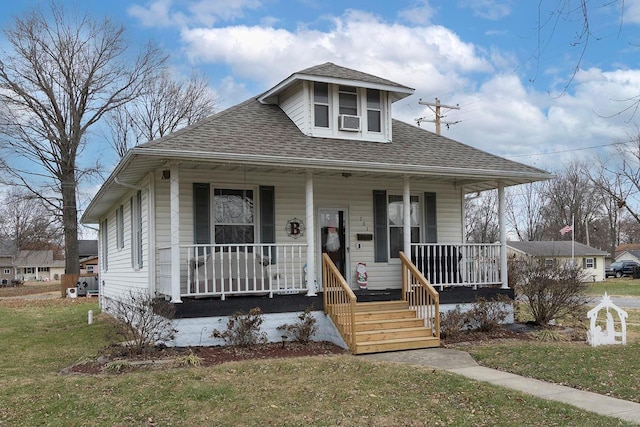 bungalow-style home with a porch, a front yard, and cooling unit