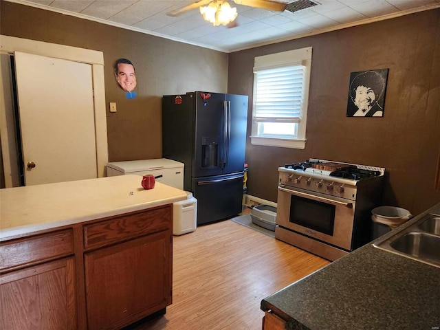 kitchen with light wood-type flooring, ceiling fan, crown molding, high end stainless steel range, and fridge with ice dispenser