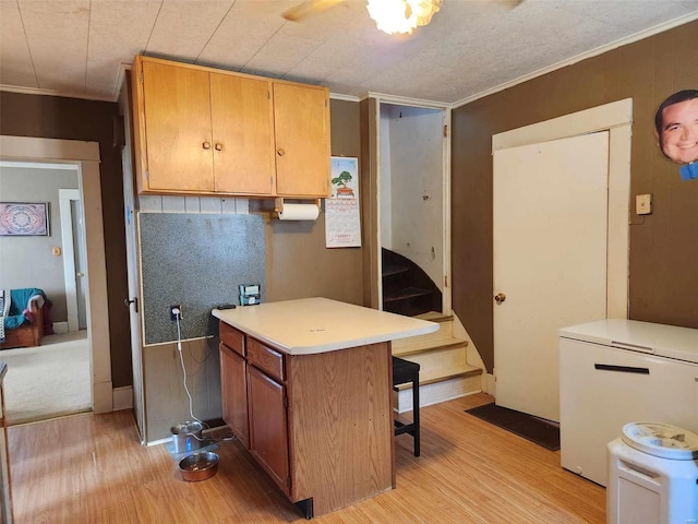 kitchen with kitchen peninsula, light hardwood / wood-style flooring, refrigerator, and ornamental molding