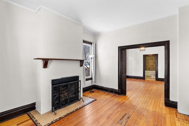 unfurnished living room featuring crown molding and wood-type flooring