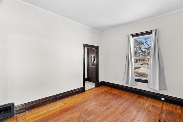 empty room featuring crown molding and wood-type flooring